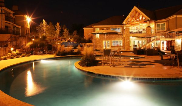 Barrewoods apartment building exterior with pool at night