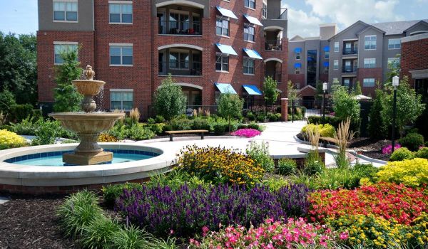 The Village at Mission Farms building exterior with gardens and flowers