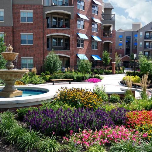 The Village at Mission Farms building exterior with gardens and flowers